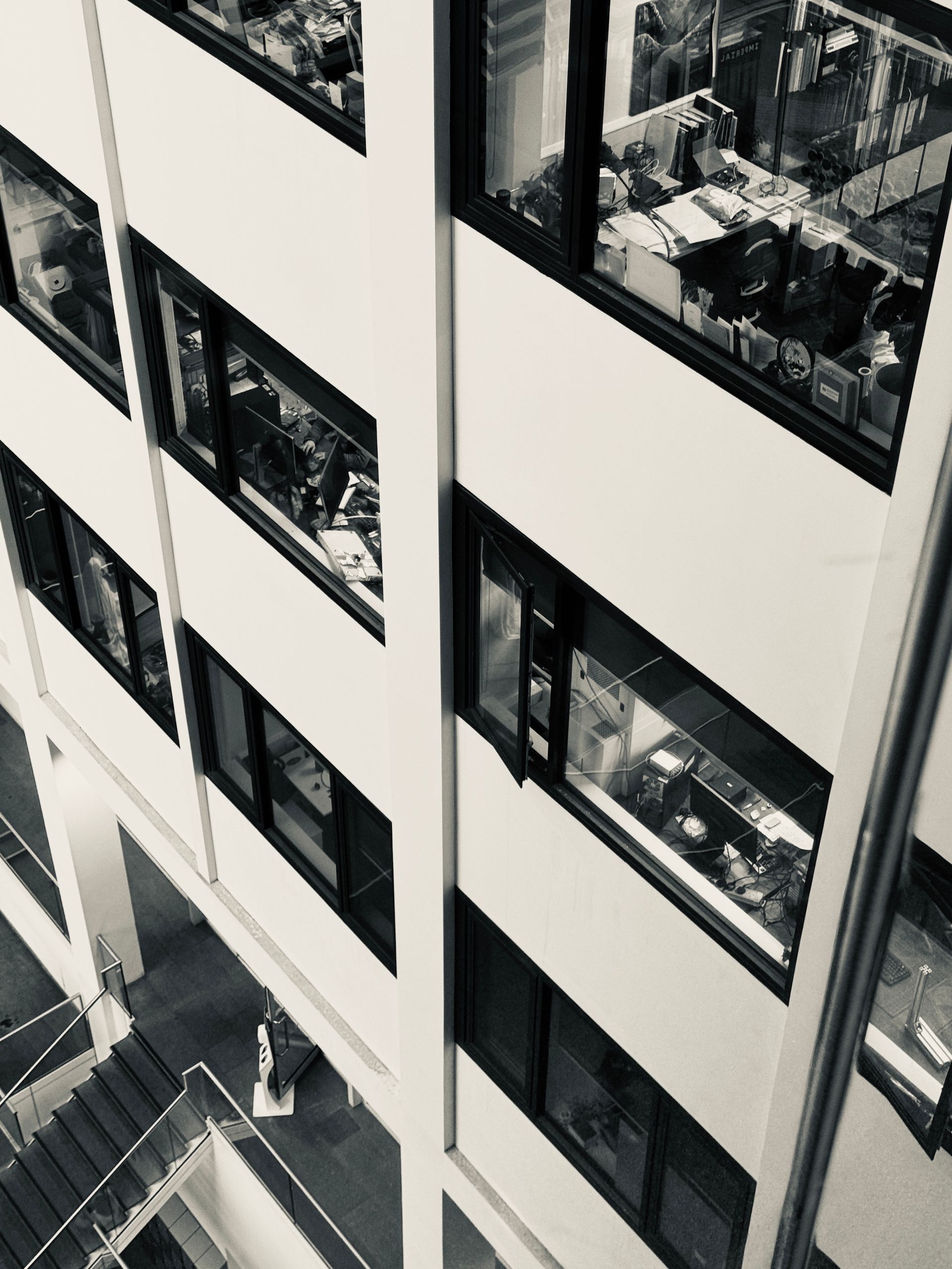 High-angle view of a bustling office with visible desks and employees.